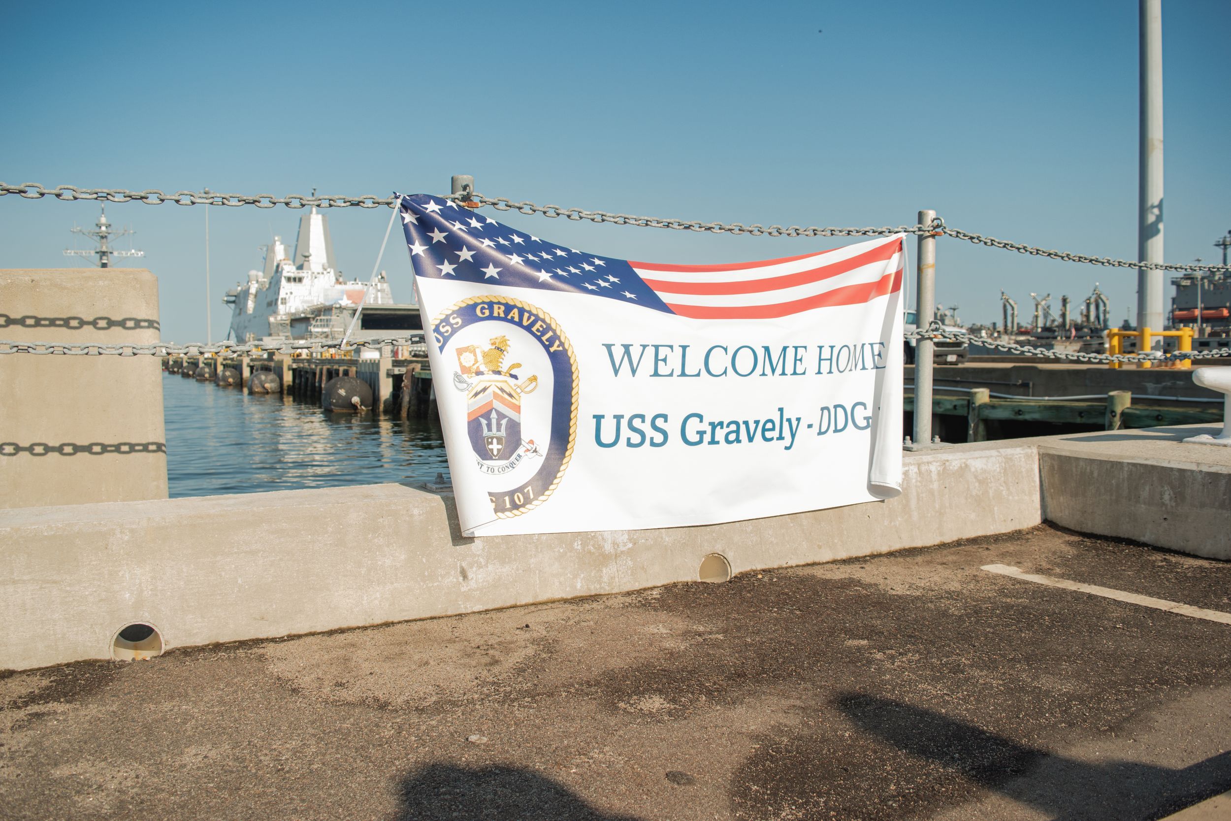 A panoramic view of a marina dock with American flags and welcome banners displayed along the waterfront.