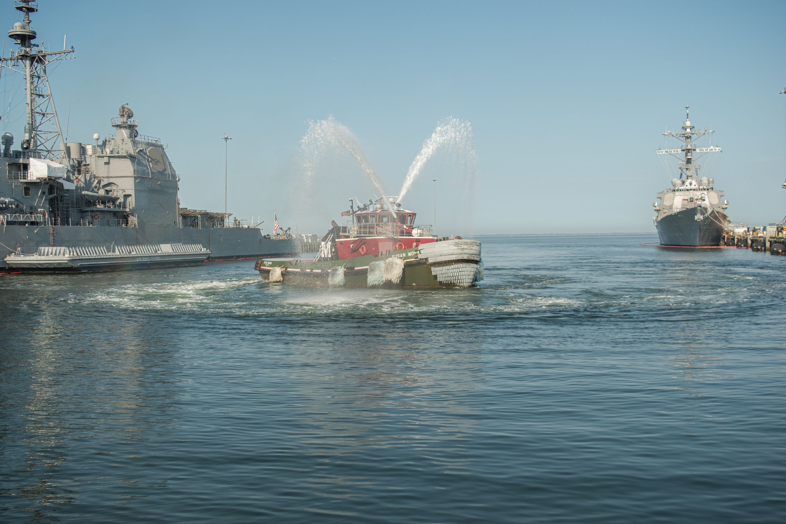 A fleet of naval warships sailing in formation across calm blue ocean waters during a maritime exercise.