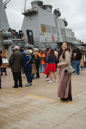 Visitors gather on the deck of a naval ship during a public tour event.