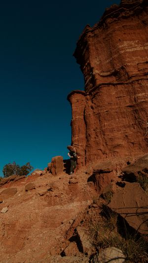 Panoramic view of towering red sandstone rock formations against a deep blue desert sky.