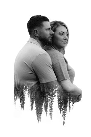 Artistic double exposure portrait of couple embracing with forest silhouette overlay in black and white.