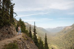 A series of scenic mountain trail views showing winding paths through evergreen forests and rugged terrain.