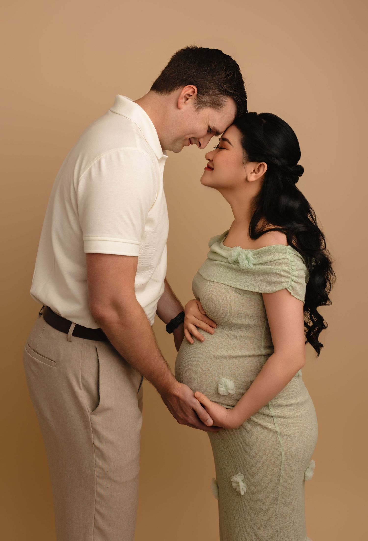 Expecting couple cradle the baby bump in an intimate moment captured by Charlottesville newborn, maternity, and family photographer.