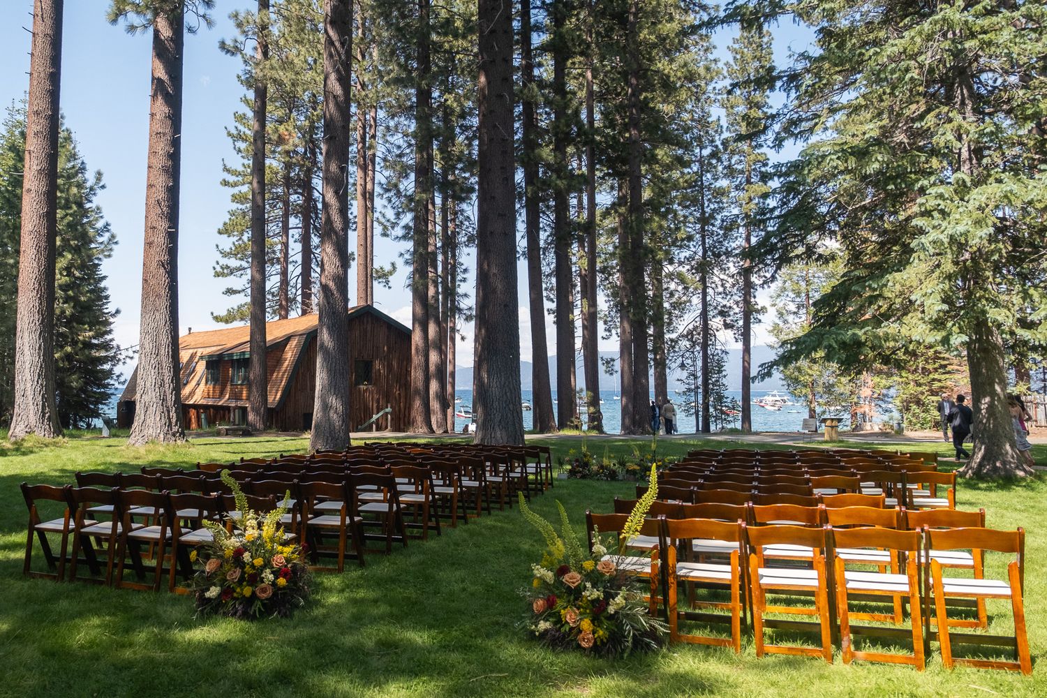Wooden chairs arranged  for an outdoor wedding ceremony at Valhalla Tahoe in a forest setting with tall pine trees.