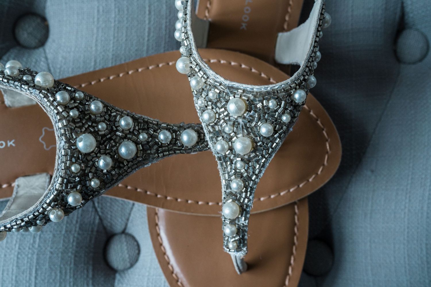 Close-up view of a brown leather sandal decorated with rhinestones, pearls and silver embellishments perfect for beach wedding Nova Scotia