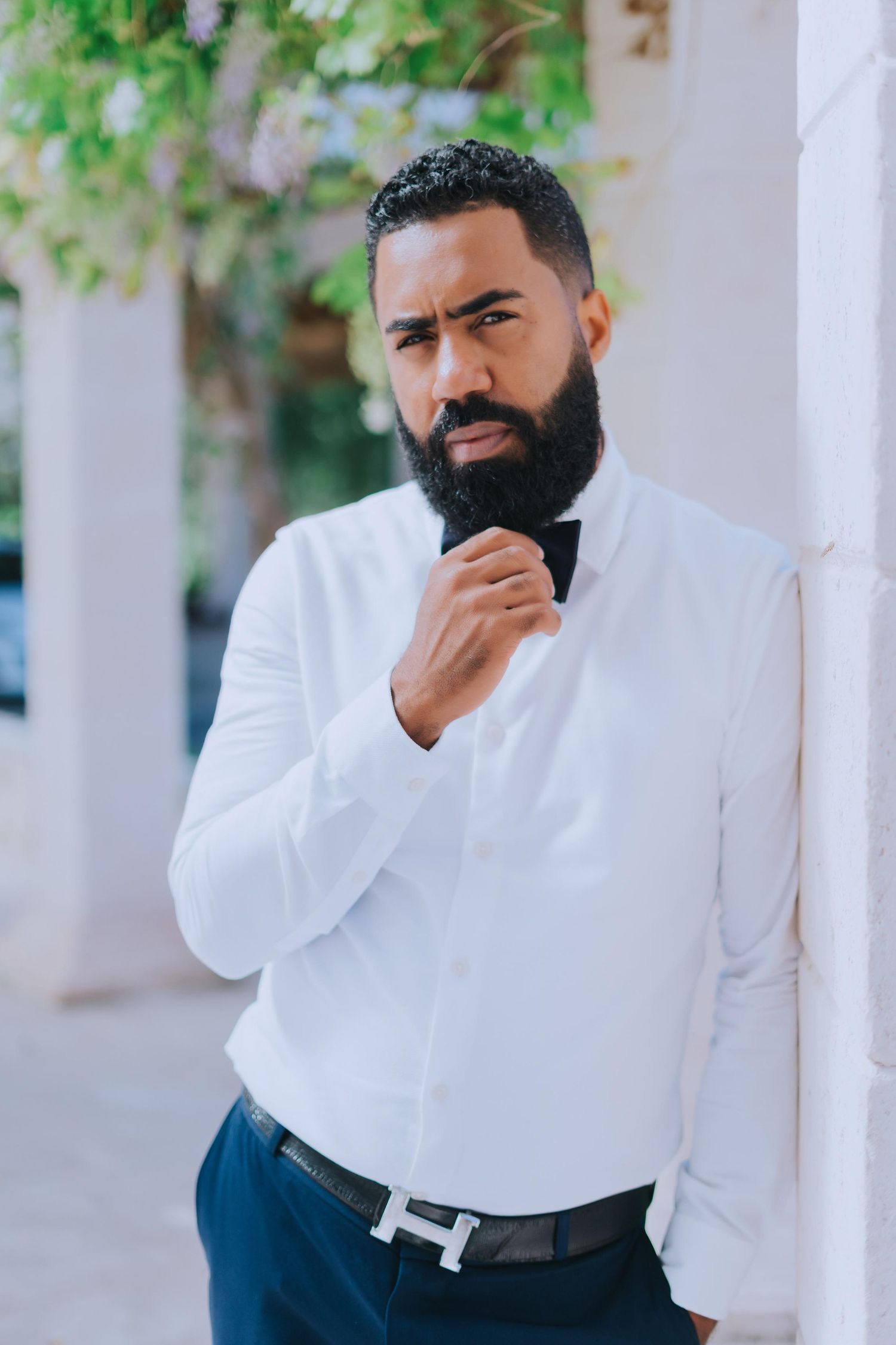 Well-dressed professional seated on wooden porch bench in formal business attire.