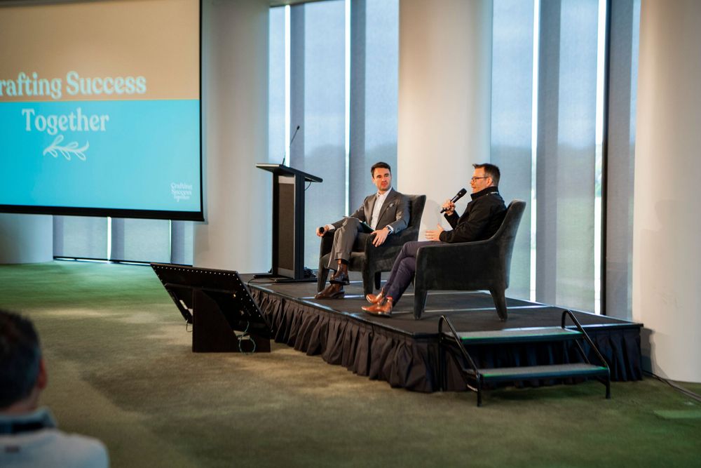 Business panel discussion setup on stage with modern presentation screen.