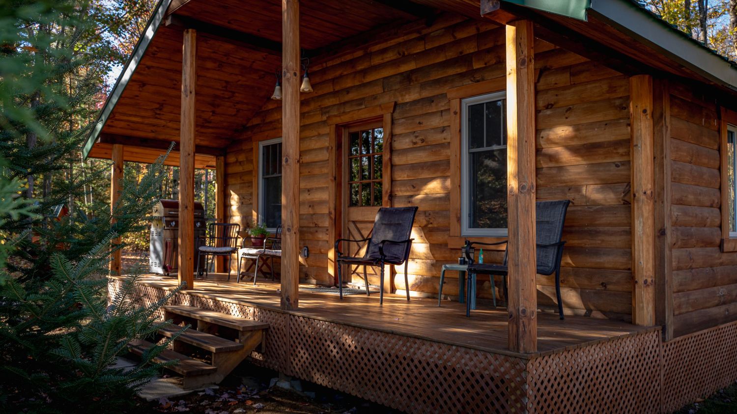 Peaceful close-up view of a wood cottage surrounded by warm wood textures and bright natural scenery at Domaine Labrador in Clarence Creek,
