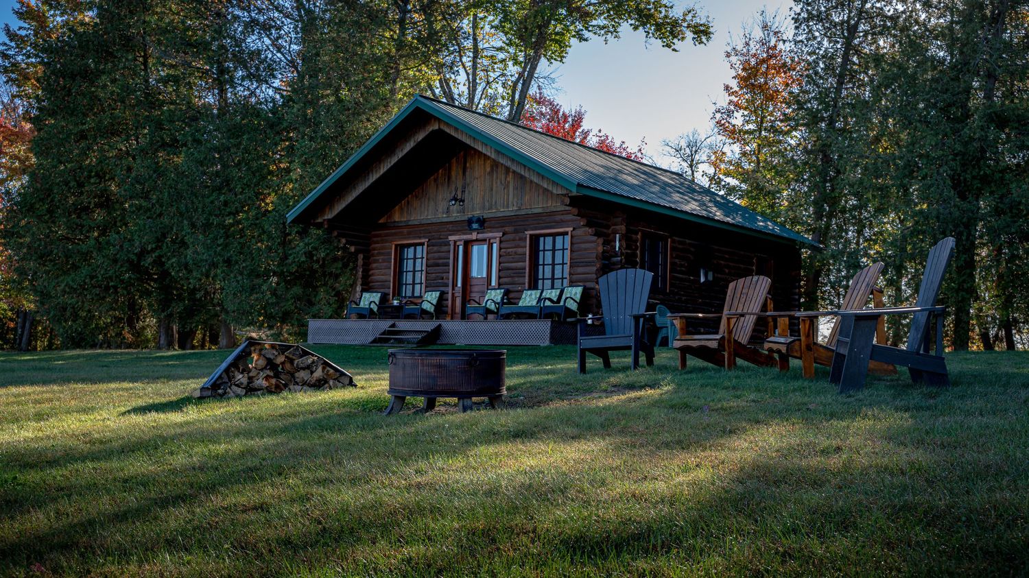 Distant view of a wood cottage nestled in the forest at Domaine Labrador in Clarence Creek, Ontario.
