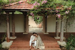 A romantic moment under a Spanish-style veranda with pink flowering vines and terracotta tiles.