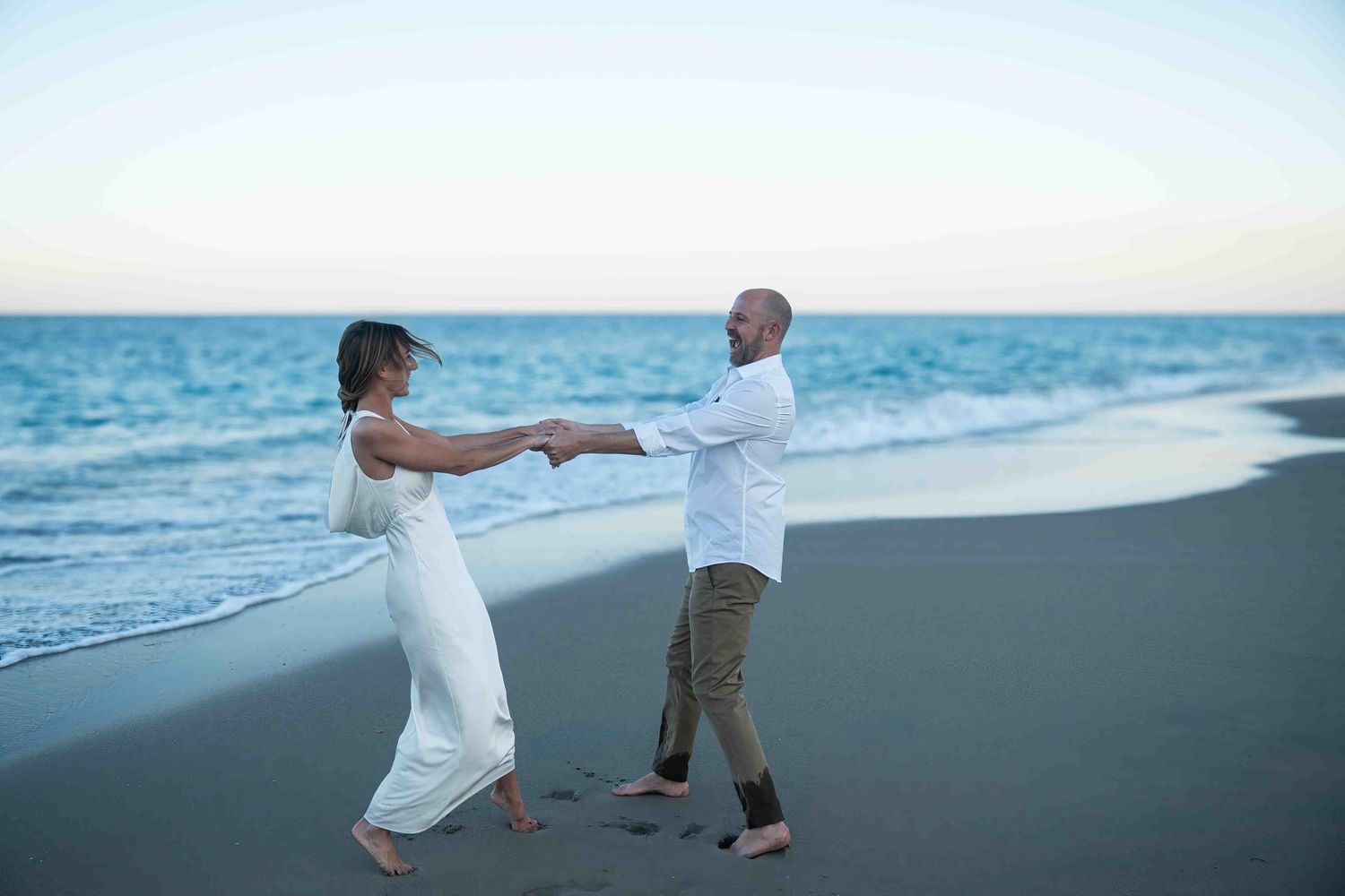 Kari and Jeff spinning around on the beach on Worth Ave.