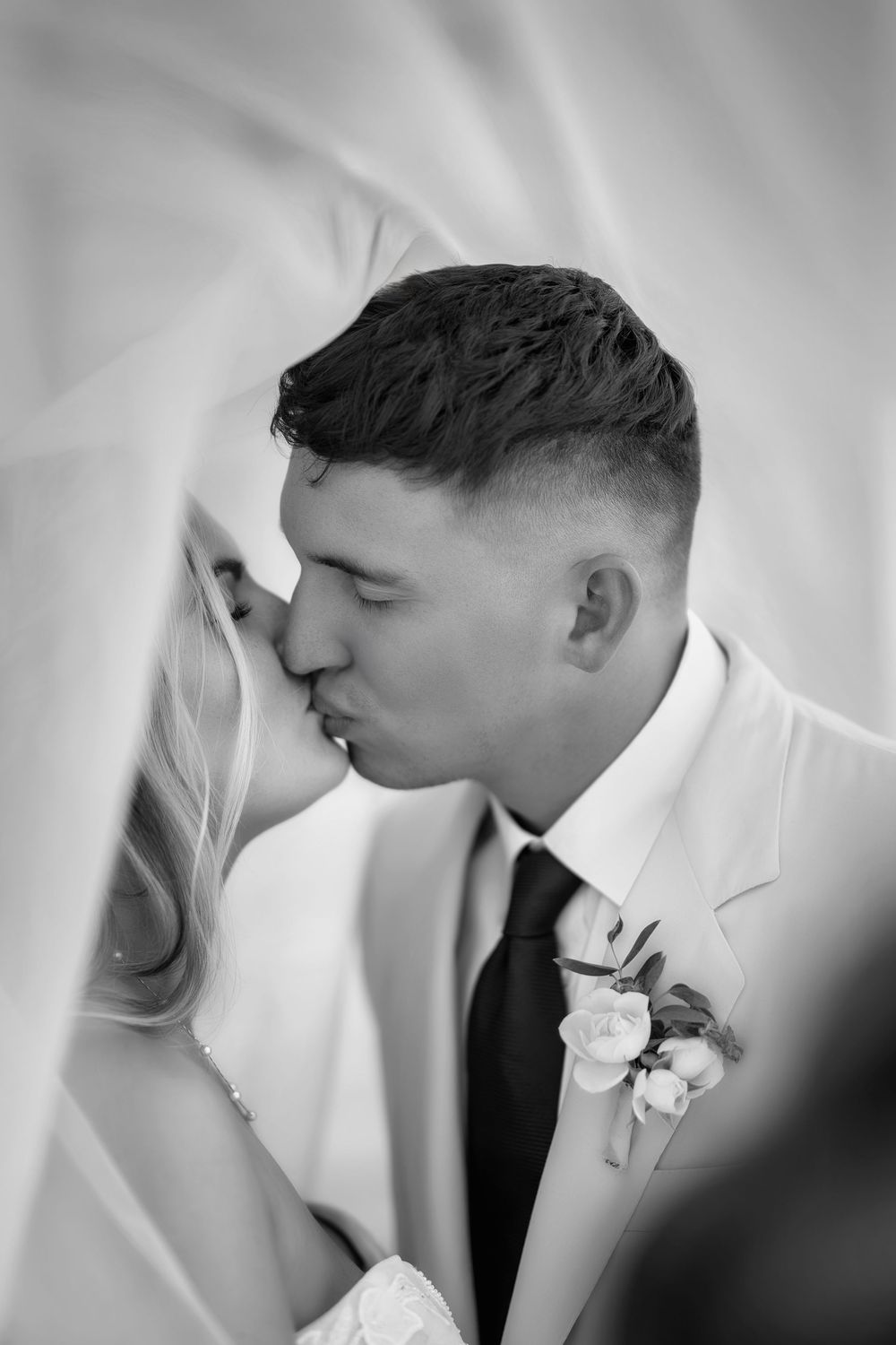 Intimate black and white portrait of a tender wedding moment.