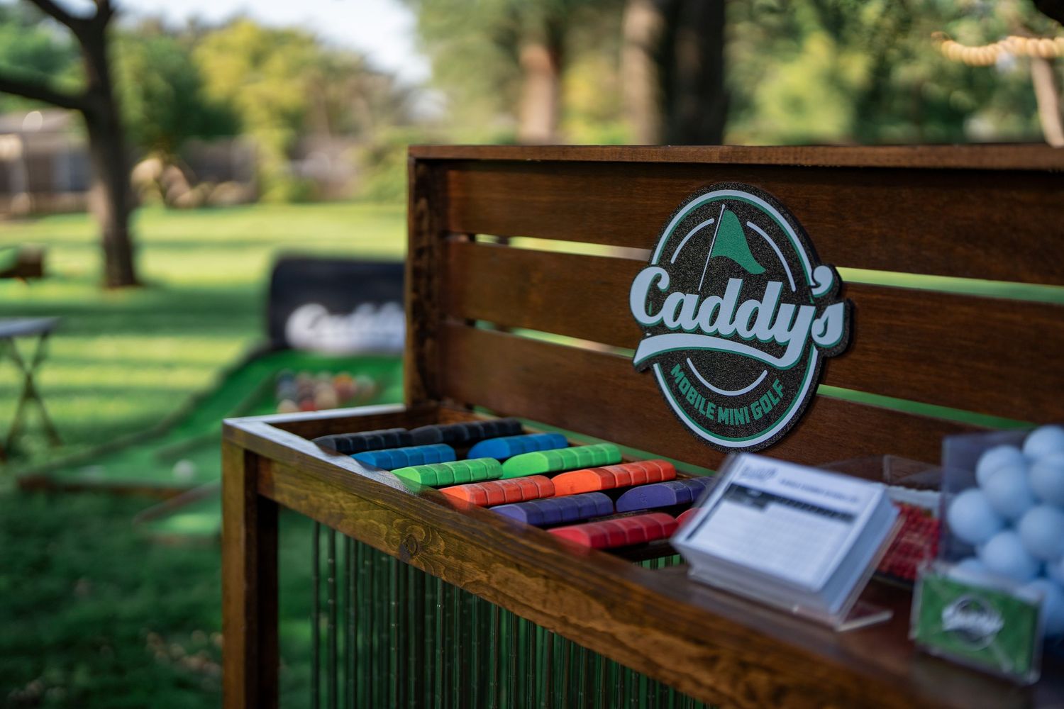 A miniature golf setup for Caddy's mobile mini golf featuring an artificial turf course with hole number 5 marked in Fresno, CA.