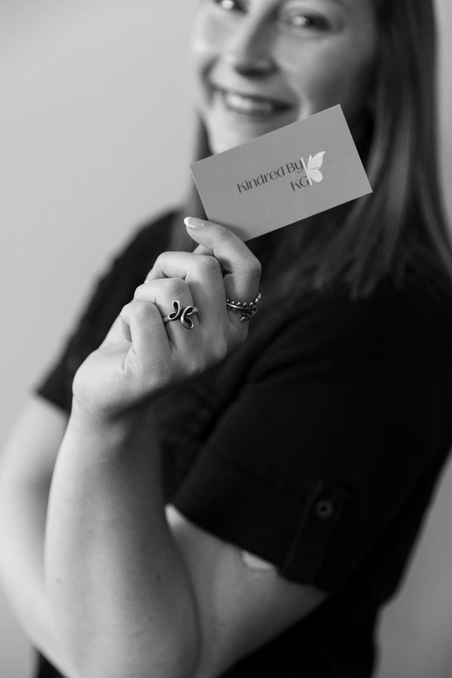 Hands holding and opening a small card in black and white photography.