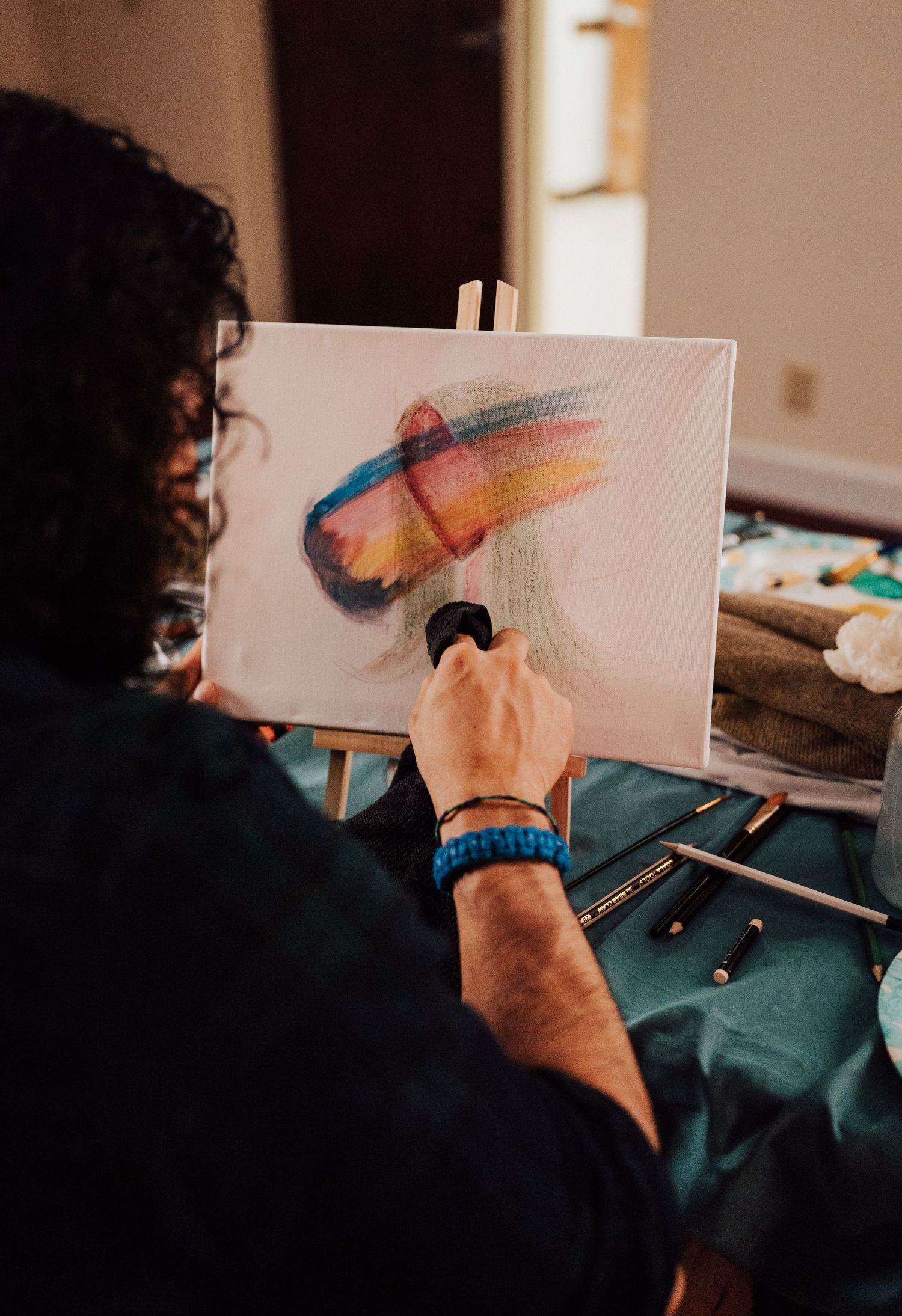 Fiancé paints a portrait of his fiancée at Sip and Paint date night event at Nicolle Aponte Photography studio in Middletown, PA