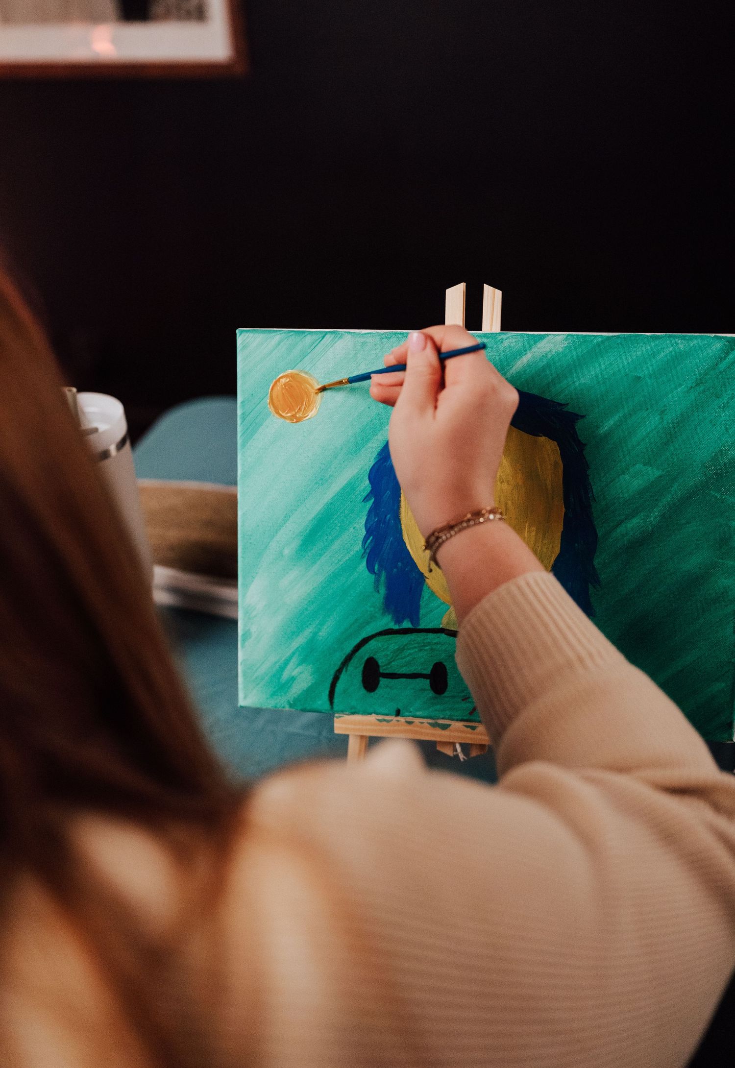 Fiancée paints a portrait of her fiancé at Sip and Paint date night event at Nicolle Aponte Photography studio in Middletown, PA