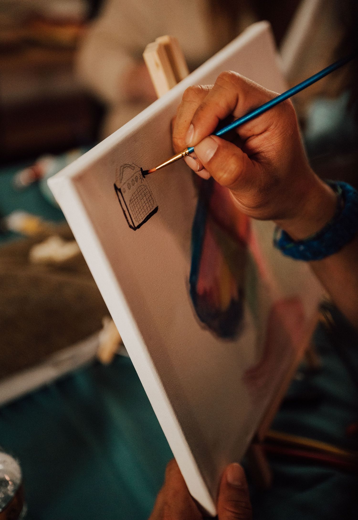 Fiancé paints a portrait of his fiancée at Sip and Paint date night event at Nicolle Aponte Photography studio in Middletown, PA