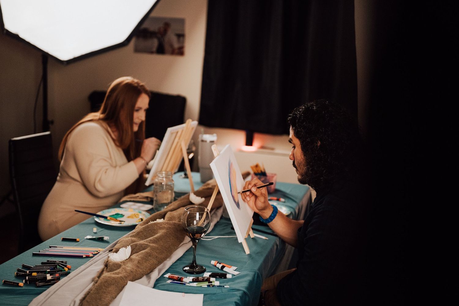 Fiancé paints a portrait of his fiancée at Sip and Paint date night event at Nicolle Aponte Photography studio in Middletown, PA