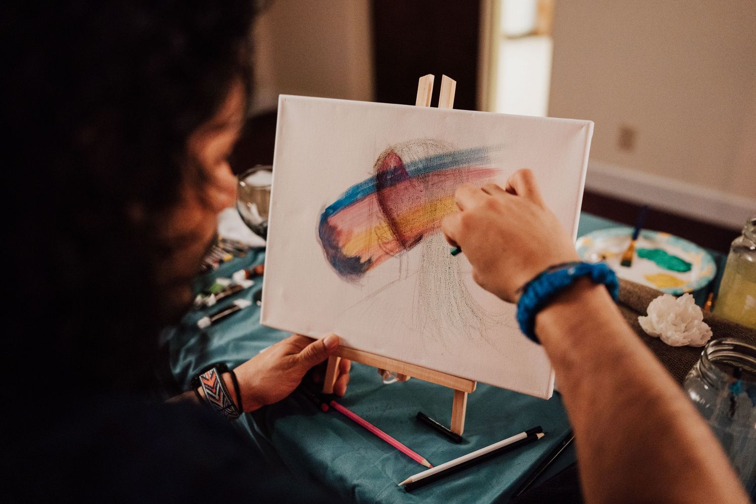 Fiancé paints a portrait of his fiancée at Sip and Paint date night event at Nicolle Aponte Photography studio in Middletown, PA