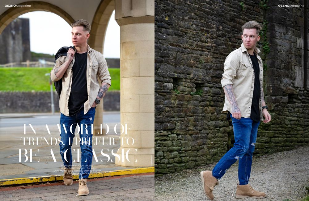 Street style fashion look with cream jacket, blue jeans and brown boots against stone architecture backdrop.
