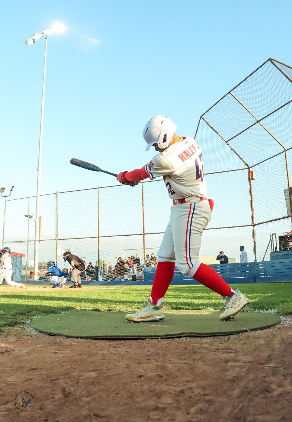 Baseball player in white uniform demonstrating batting stance sequence on field.
