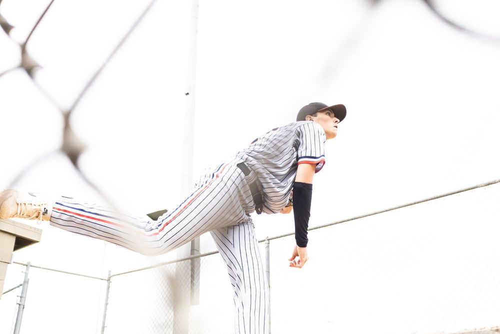 A baseball pitcher in pinstriped uniform demonstrates throwing motion sequence from wind-up to follow through.