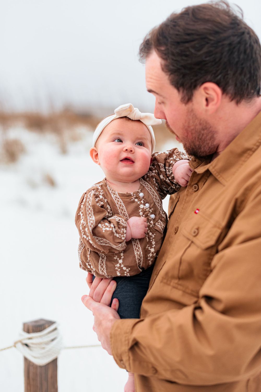 Winter outdoor portrait with baby wearing brown floral outfit.
