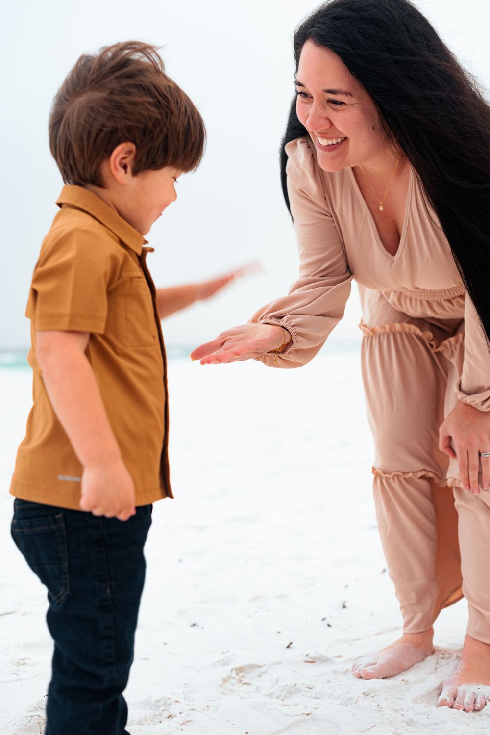 A playful moment captured between two people on a bright sandy beach.