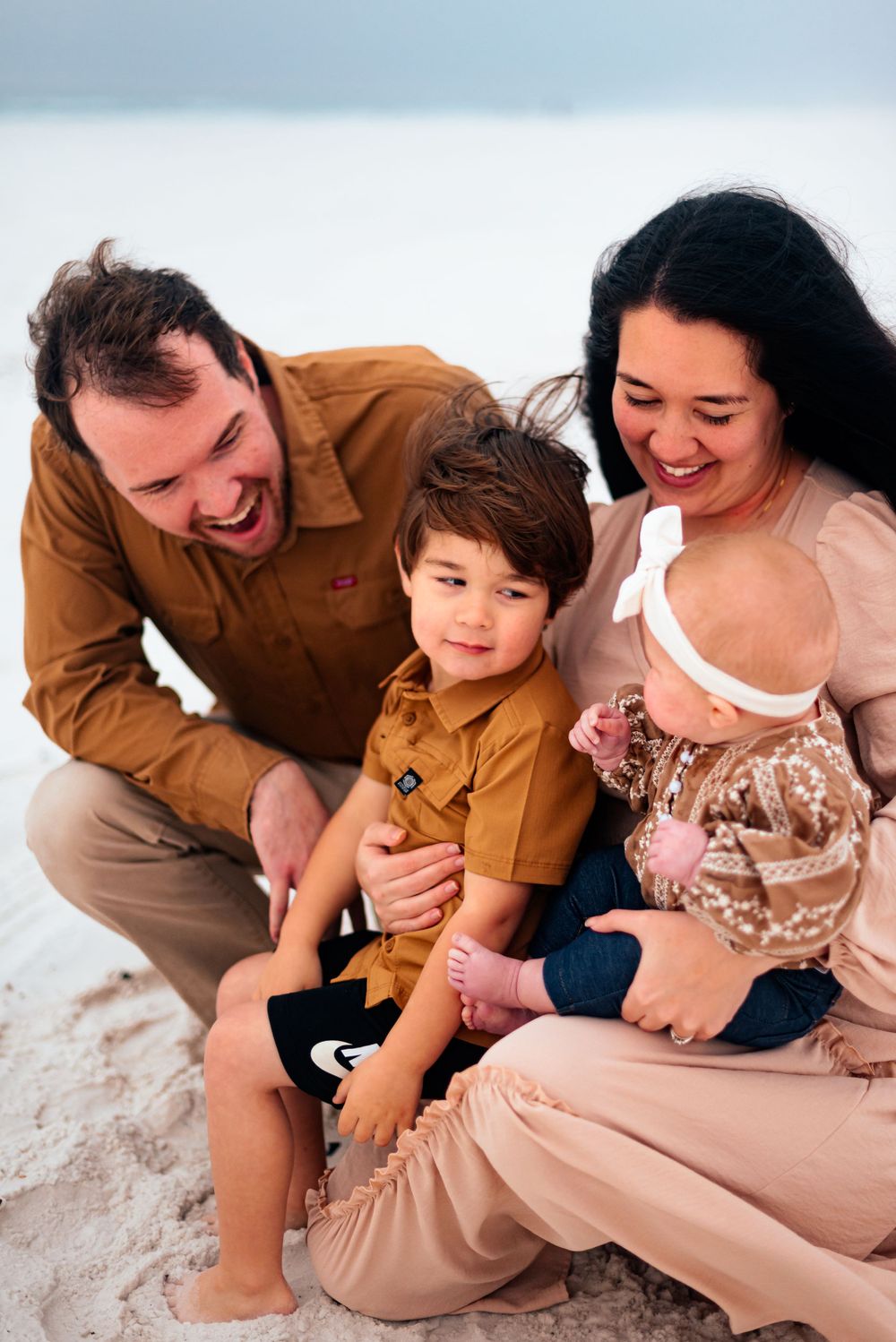 A candid moment of shared laughter on a sunny beach day.