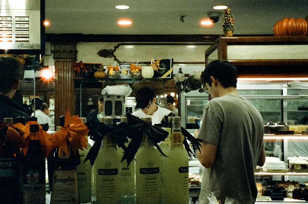 Retro diner interior with Halloween decorations and customers at counter.