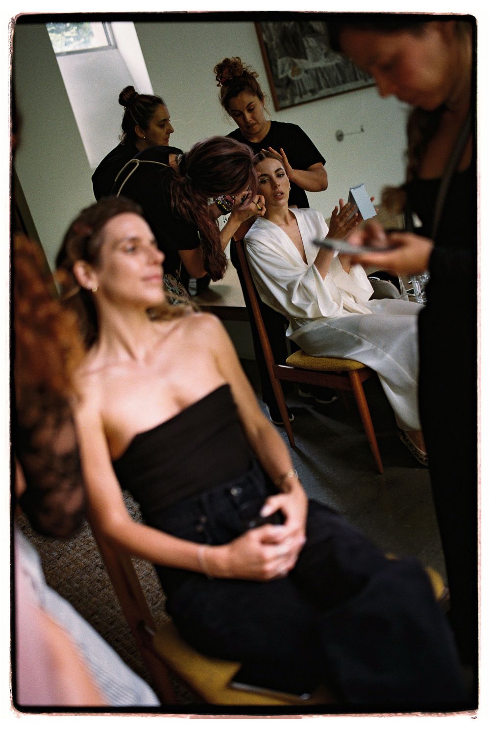 Behind the scenes preparation in a dressing room with styling chairs and mirrors.