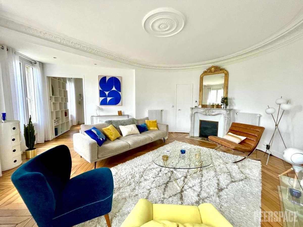 Femme entrepreneure posant près d’une grande fenêtre dans un décor chic parisien