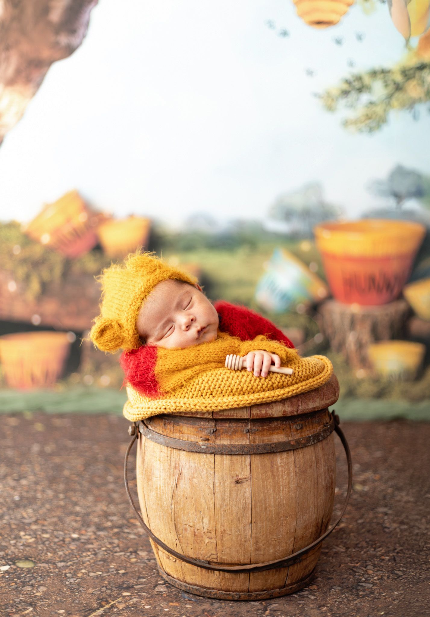 Rustic wooden bucket with metal handle and hoops sits on hardwood floor surface.