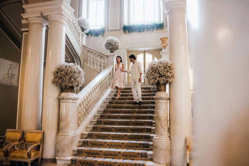 A grand marble staircase in an elegant wedding venue showcases multiple angles of the same setting in a photo collage.