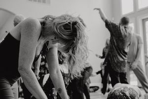 Black and white photo of dancers in an expressive movement class with natural light.