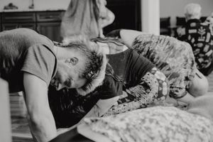 Black and white image of a person lying on the floor during a movement exercise.