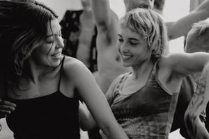 Two people dancing together with carefree expressions in a black and white candid shot.