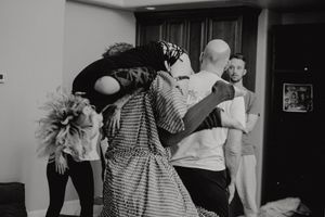 A black and white photo of dancers practicing in a studio space with expressive body movements.