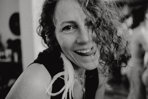 Black and white portrait featuring curly hair and natural lighting indoors.