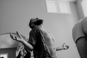 Person with eyes closed gestures expressively during dance movement.