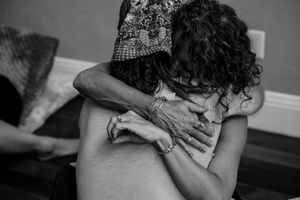 Close-up black and white image of two people embracing in an intimate moment.