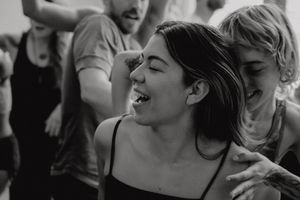 Black and white candid photo capturing joyful laughter during a dance session.