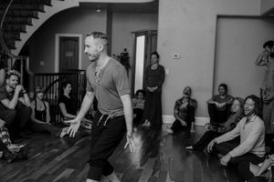 Performer engages with seated audience during an intimate indoor performance.