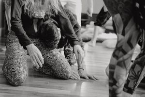 Black and white image showing participants on the floor during a movement exercise.
