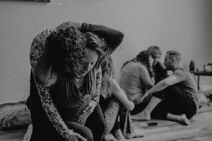 Monochromatic image of dancers practicing expressive movements in a studio.