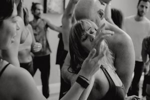 Black and white photo of dancers expressing joy and movement at a dance class or workshop.