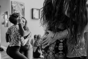 Close-up black and white shot of people embracing during an intimate gathering.