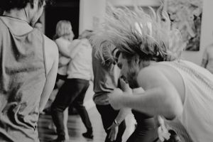Dancers in motion captured in a blurred black and white photograph.
