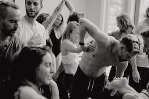 Dancers in casual attire practicing partner moves in a bright studio space.