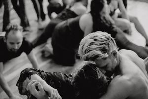 Intimate black and white photograph of people lying close together on floor.